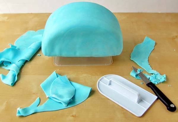 aplicando-fondant-azul-a-una-tarta-arcoiris